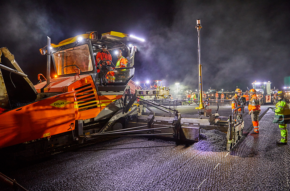 A paver equipped with two TrimbleMT900 Machine Targets begins laying asphalt, to the left of the axis of the runway - Photo La Compagnie Générale de Photographie